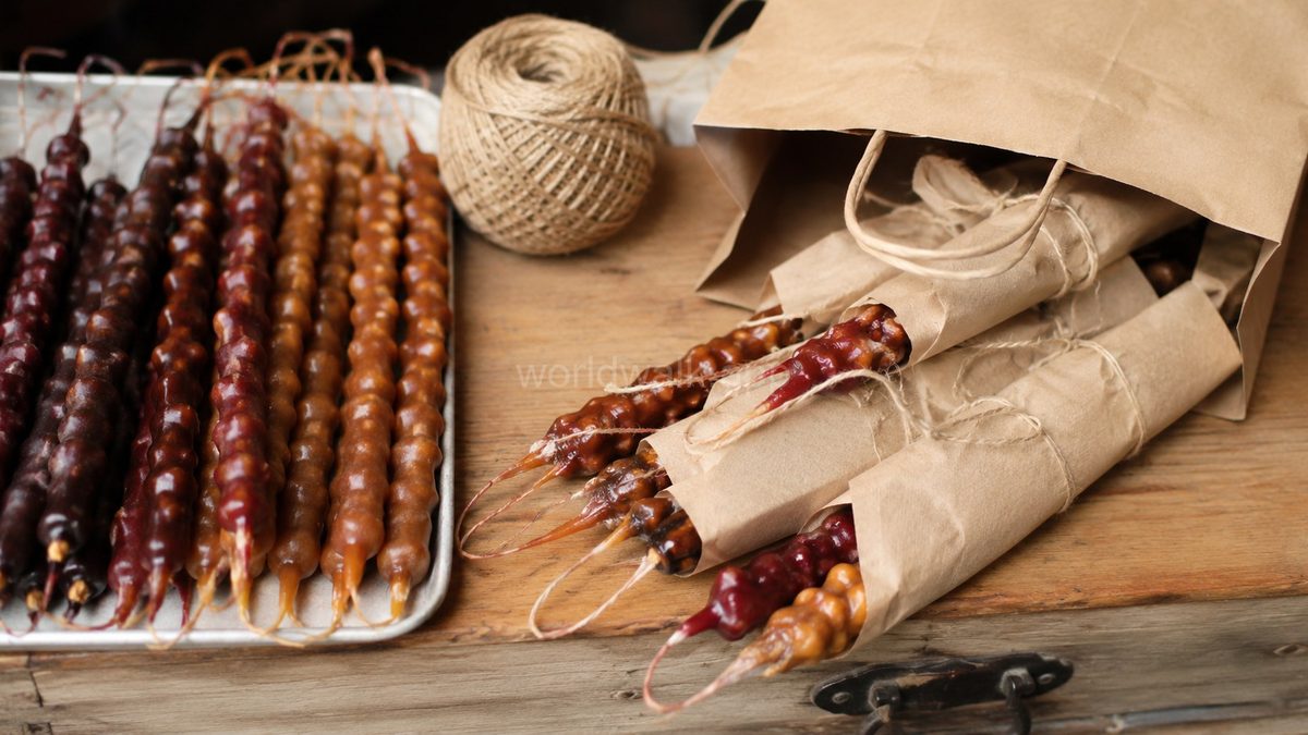 Churchkhela in different colours and varieties, wrapped in brown paper as souvenir packaging