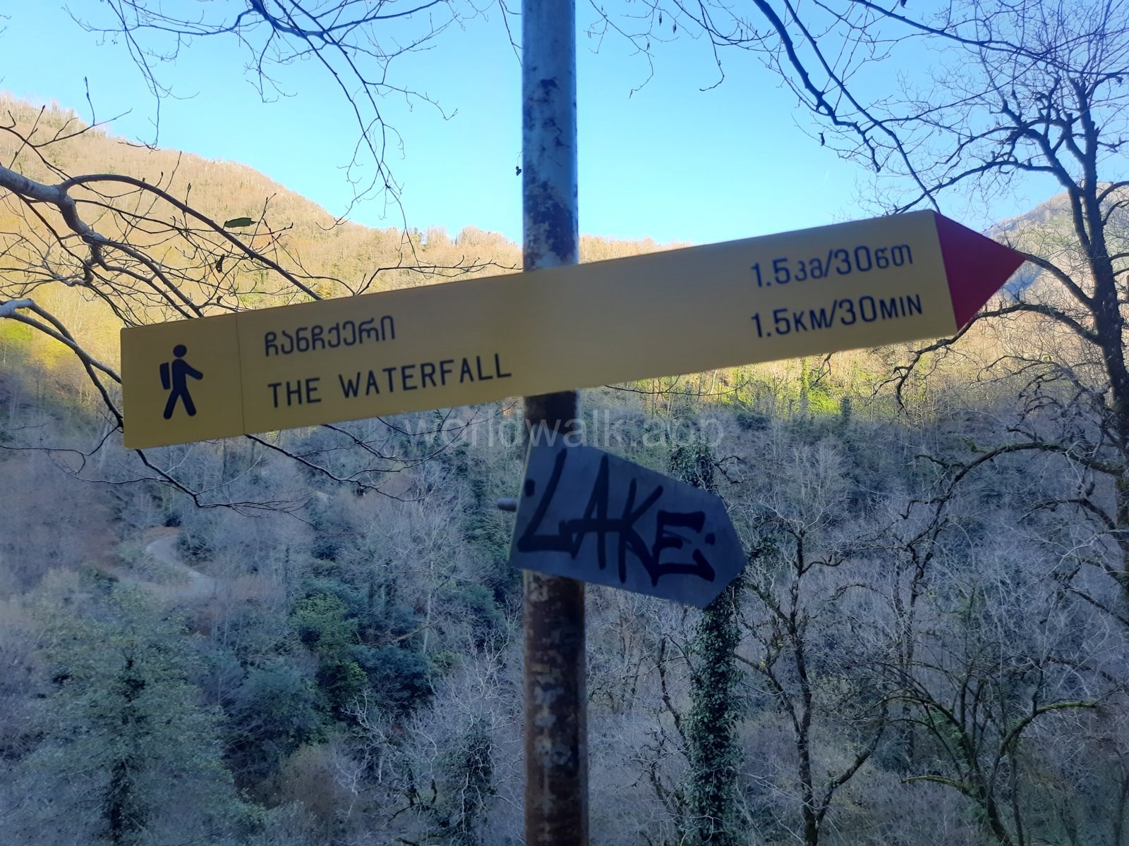 Trail sign to the waterfall and lake on a frosty December day in Mtirala