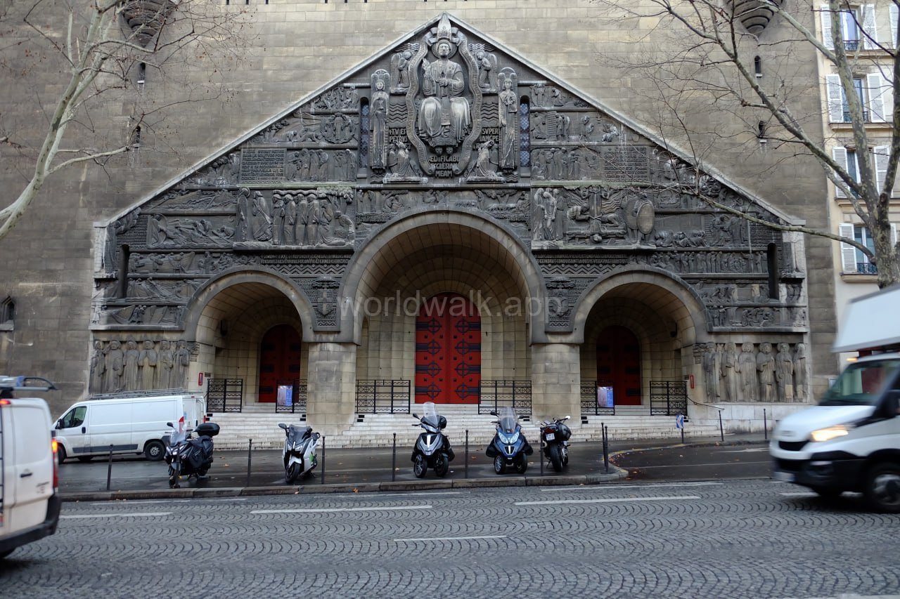 A Paris street with scooters parked outside a Romanesque church