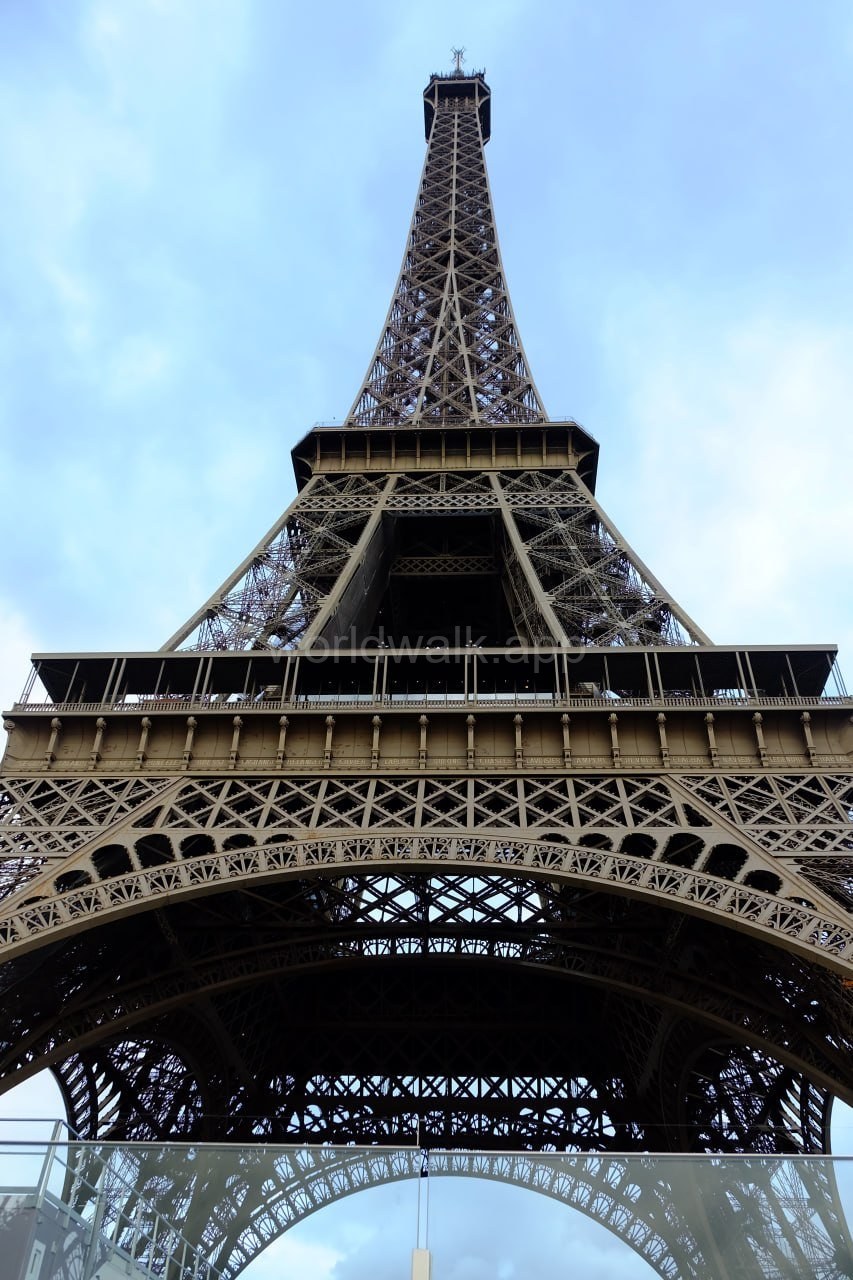 Looking up at the Eiffel Tower from directly beneath its arches