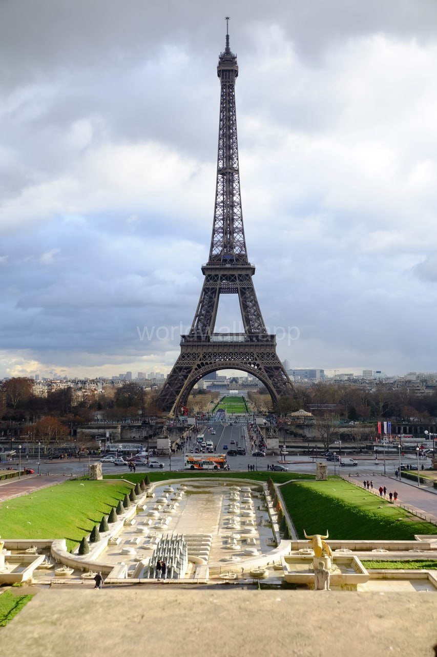 Eiffel Tower seen from the Trocadéro Gardens fountains, with a golden statue in the foreground