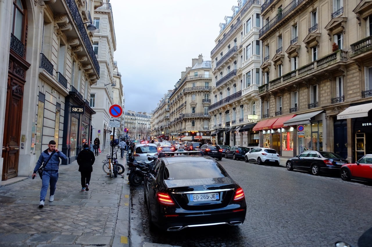 A busy street in central Paris — traffic, taxis and pedestrians near a metro station